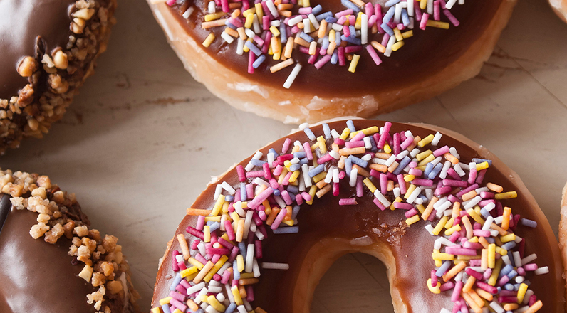 Chocolate glazed donuts covered in sprinkles