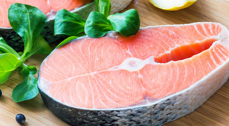 A fresh salmon steak being prepared to cook