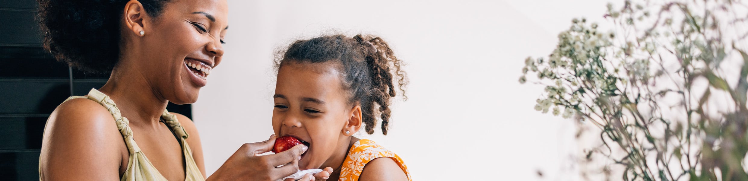 mother giving her daughter a strawberry