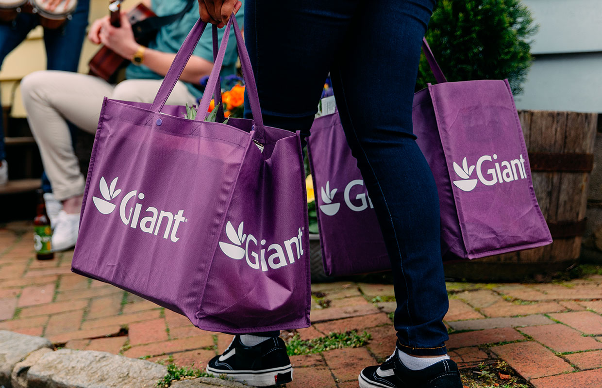 person holding purple Giant reusable shopping bags