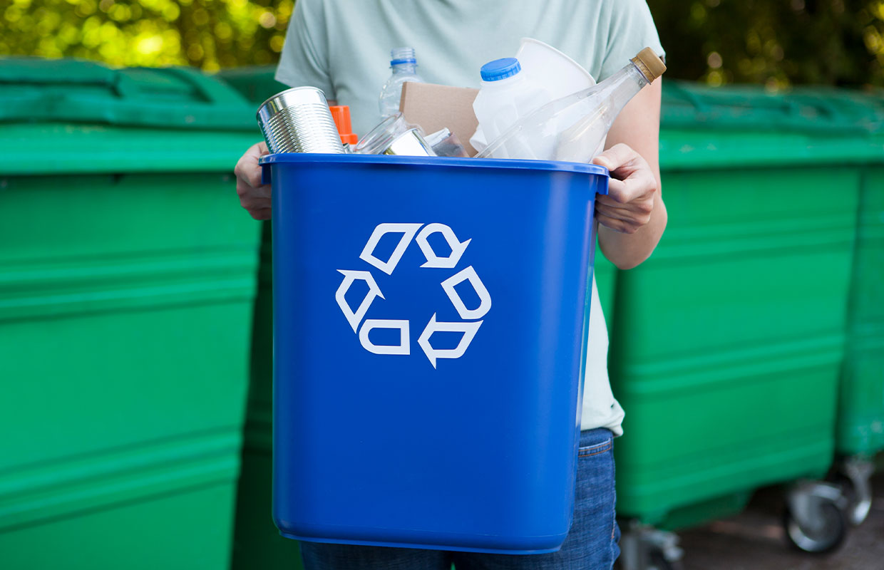 person holding a recycling bin